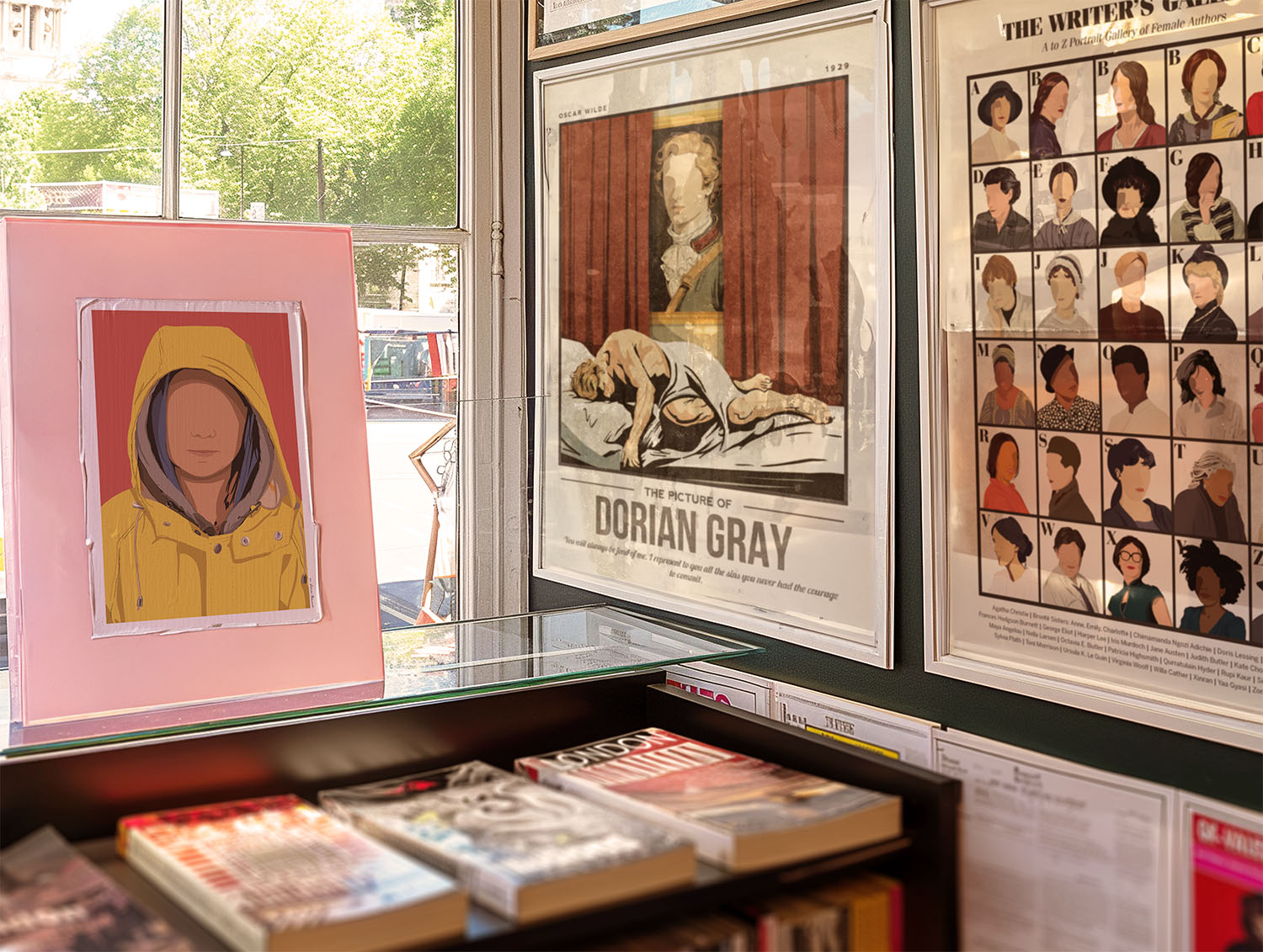 Framed artwork and books displayed on a shelf with a window view.